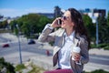 Beautiful madam talking on phone while holding cup of coffee