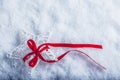 Beautiful magical vintage white star tied with a red ribbon on a white snow background. Winter and Christmas concept. Royalty Free Stock Photo