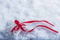 Beautiful magical vintage white star tied with a red ribbon on a white snow background. Winter and Christmas concept. Royalty Free Stock Photo