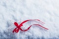 Beautiful magical vintage white star tied with a red ribbon on a white snow background. Winter and Christmas concept. Royalty Free Stock Photo