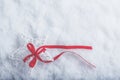 Beautiful magical vintage white star tied with a red ribbon on a white snow background. Winter and Christmas concept. Royalty Free Stock Photo