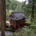 Beautiful main wooden entrance gate in front of japanese temple among fresh green forest in Nikko World Heritage Sites Royalty Free Stock Photo