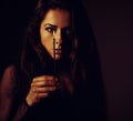 Beautiful makeup female model holding in hand the candle at shado dark night in black dress and looking mystery. Focus on the Royalty Free Stock Photo
