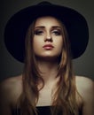 Beautiful makeup woman with long blond hair style in black hat on studio background.. Closeup Royalty Free Stock Photo