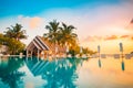 Sunset on Maldives island, luxury water villas resort and wooden pier. Beautiful sky and clouds and beach background for summer