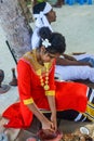 Beautiful maldivian woman in national dress cooking coconut