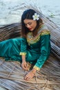 Beautiful maldivian woman in national dress making plates from dry leaves