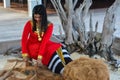 Beautiful maldivian woman in national dress making ropes