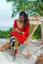 Beautiful maldivian woman in national dress producing ropes