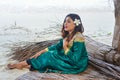 Beautiful maldivian woman in national dress sitting on the sheets made from dry leaves