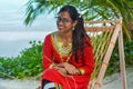 Beautiful maldivian woman in national dress smiling while crafting ropes