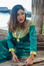 Beautiful maldivian woman in traditional national dress making roof sheets