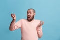 Beautiful male half-length portrait isolated on blue studio backgroud. The young emotional surprised man Royalty Free Stock Photo