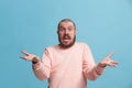 Beautiful male half-length portrait isolated on blue studio backgroud. The young emotional surprised man Royalty Free Stock Photo