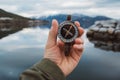 Beautiful male hand holds a magnetic compass against the background of the mountain and a lake. The concept of finding yourself Royalty Free Stock Photo