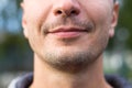 Beautiful male lips of Caucasian appearance close-up. The slight smile and the bristle of stubble on his face. Young man, chin, sh