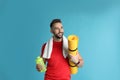 Beautiful man with yoga mat, towel and shaker on turquoise background Royalty Free Stock Photo