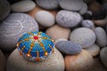 Beautiful mandala hand painted on a sea stone