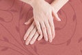 Beautiful manicure. Hands of the woman on a background of a stylish carpet of terracotta color with a vegetative ornament