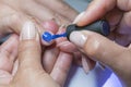 Beautiful manicure process. Nail polish being applied to hand, polish is a blue color. close up