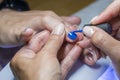 Beautiful manicure process. Nail polish being applied to hand, polish is a blue color. close up