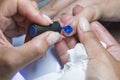 Beautiful manicure process. Nail polish being applied to hand, polish is a blue color. close up