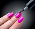 Beautiful manicure process. Nail polish being applied to hand, polish is a pink color. Royalty Free Stock Photo