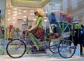 Beautiful mannequin of a blond hair woman riding the tricycle rickshaw.