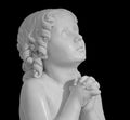 Beautiful marble statue of an pray infant angel isolated on black Royalty Free Stock Photo