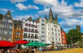 Beautiful market square, colorful medieval houses, church tower, cafe restaurants, blue summer sky