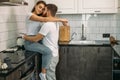 Beautiful married couple kissing in kitchen at home