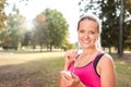 Beautiful mature blonde woman running at the park on a sunny day. Female runner listening to music while jogging Royalty Free Stock Photo