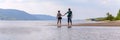 A beautiful mature couple walks along the wild beach holding hands against the background of the Volga open spaces and the Zhiguli Royalty Free Stock Photo