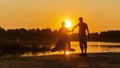 Beautiful mature couples dance on a wild beach in the rays of the setting sun