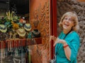 Beautiful mature happy tourist woman stays smiling at jewelry show-window Royalty Free Stock Photo