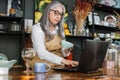 Mature lady using laptop while receiving goods at decor shop Royalty Free Stock Photo