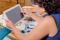 Beautiful mature seamstress using tablet computer Royalty Free Stock Photo