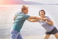 Beautiful mature sportive couple doing gymnastic exercises on the beach Royalty Free Stock Photo