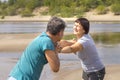 Beautiful mature sportive couple doing gymnastic exercises on the beach Royalty Free Stock Photo