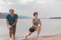 Beautiful mature sportive couple doing gymnastic exercises on the beach Royalty Free Stock Photo