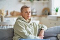 Beautiful mature woman in casual clothes dreaming about something while relaxing on sofa at home Royalty Free Stock Photo