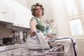 Beautiful mature woman with curlers ironing Royalty Free Stock Photo