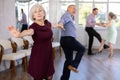 Beautiful mature woman in dance salon studying with her partner to dance couples ballroom dance paso doble