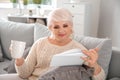 Beautiful mature woman drinking coffee while reading book at home Royalty Free Stock Photo