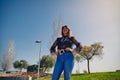 Beautiful and mature woman in fashionable dress is with her hands on her hips posing for a photo session in front of a fountain in Royalty Free Stock Photo