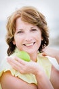 Beautiful mature woman holding an apple