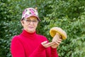 Beautiful mature woman holding in her hands a big white mushroom freshly plucked