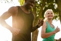 Beautiful mature woman jogging together with trainer outdoors in park Royalty Free Stock Photo