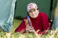 Beautiful mature woman lies in a tent and holds a bottle of pure mineral water Royalty Free Stock Photo