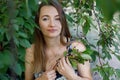 A beautiful Mature woman with long hair collects cherry berries from a tree. Everyday life of a European woman in the village Royalty Free Stock Photo